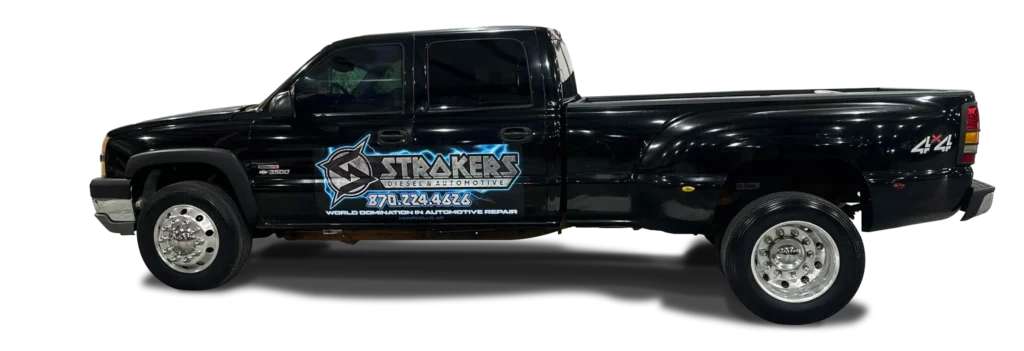 A black pickup truck with Stakers Diesel & Automotive and a phone number displayed on the driver-side door in large lettering, advertising diesel and automotive repair services.
